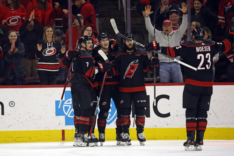 Carolina Hurricanes' Martin Necas, center, celebrates after his goal with teammates Dmitry Orlov, left, Jalen Chatfield, right, and Stefan Noesen (23) during the first period of an NHL hockey game against the Minnesota Wild in Raleigh, N.C., Sunday, Jan. 21, 2024. (AP Photo/Karl B DeBlaker)
