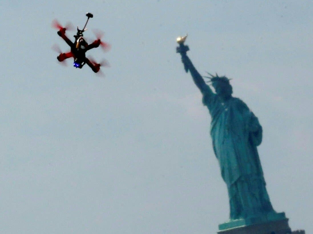 Quadcopter drones fly over the Statue of Liberty during the practice event before the National Drone Racing Championship at Governors Island in New York on August 5, 2016. (AFP via Getty Images)