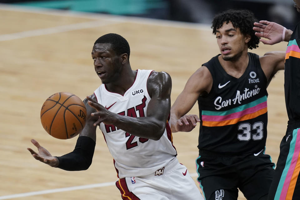 Miami Heat guard Kendrick Nunn (25) moves the pall past San Antonio Spurs guard Tre Jones (33) during the second half of an NBA basketball game in San Antonio, Wednesday, April 21, 2021. (AP Photo/Eric Gay)