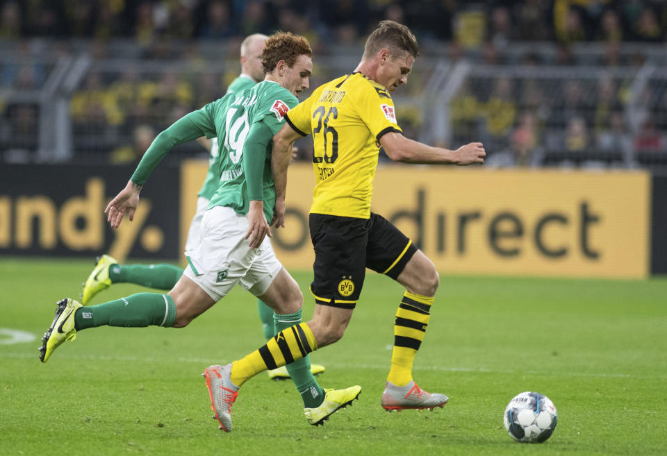 Lukasz Piszczek (derecha) del Borussia Dortmund y Josh Sargent de Bremen durante el partido de la Bundesliga, el sábado 28 de septiembre de 2019, en Dortmund, Alemania. (Bernd Thissen/dpa vía AP)