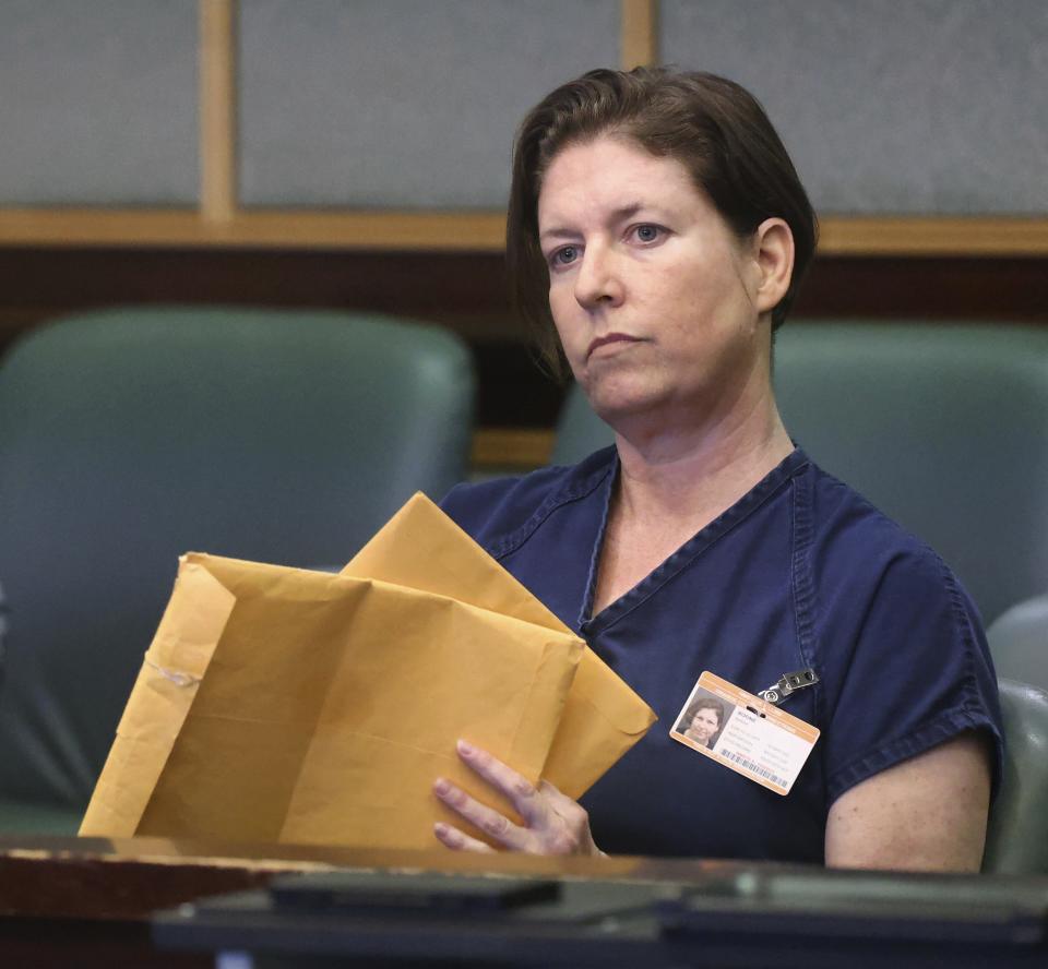 Defendant Sarah Boone holds envelopes during a pre-trial hearing in Orlando, Fla., Friday, June 7, 2024. Boone was arrested after detectives said her boyfriend died when he climbed into a suitcase as a joke and she zipped him inside. (Joe Burbank/Orlando Sentinel via AP)