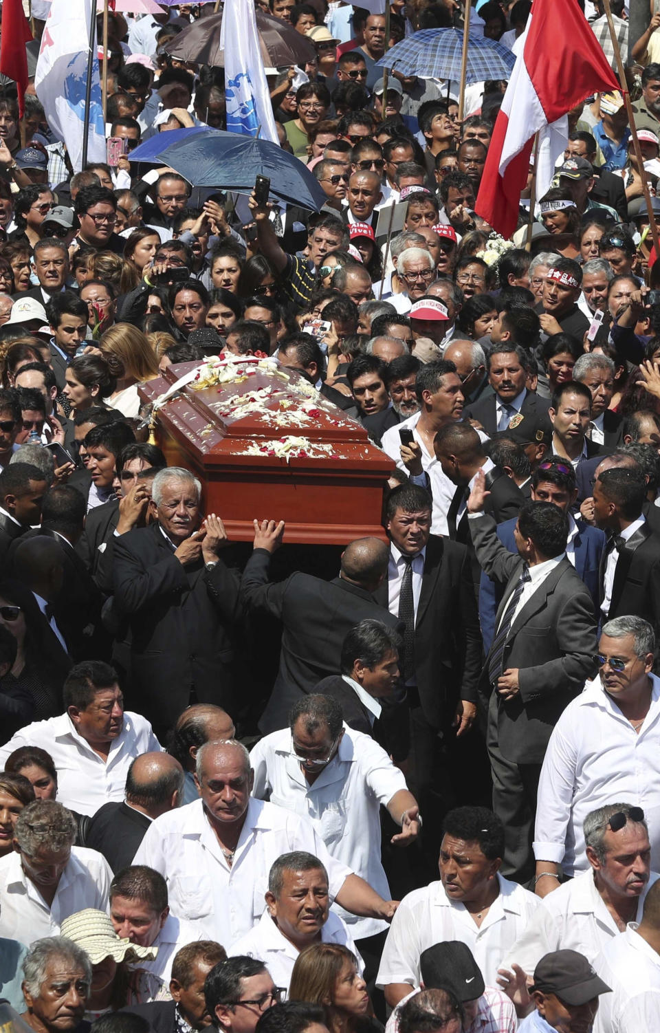 People carry the coffin of Peru's late President Alan Garcia during his funeral procession in Lima, Peru, Friday, April 19, 2019. Garcia shot himself in the head and died Wednesday as officers waited to arrest him in a massive graft probe that has put the country's most prominent politicians behind bars and provoked a reckoning over corruption. (AP Photo/Martin Mejia)