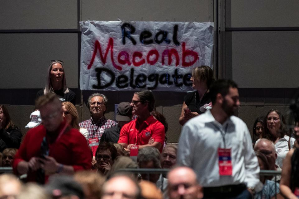 A "Real Macomb Delegates" sign hangs in the back end of the exhibition hall during the MIGOP State Nominating Convention at the Lansing Center in Lansing on Saturday, August 27, 2022.