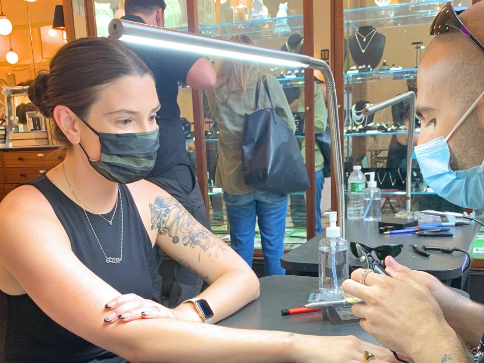 The author waits for the jeweler at Catbird to weld a bracelet onto her wrist.