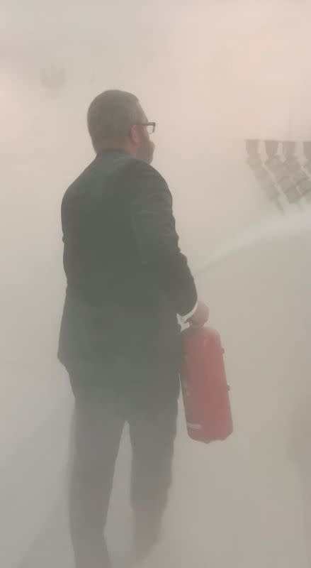 Grzegorz Braun, far-right Polish lawmaker from Confederation party, holds a fire extinguisher to put out Hanukkah candles at the parliament in Warsaw