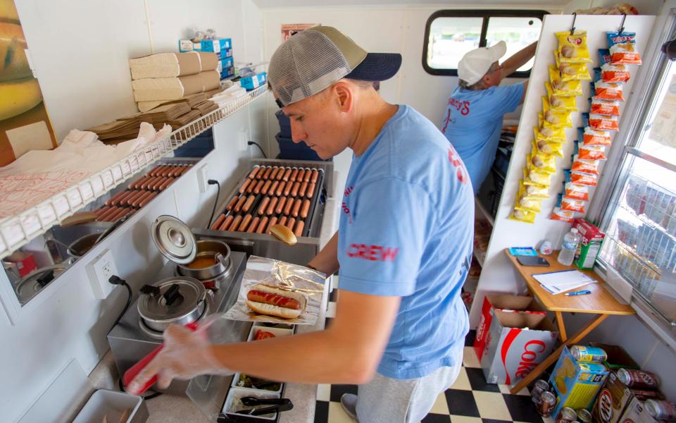 Kyle Hemsing, left, prepares a customer's order while Steven Hemsing works in the back ground on keeping supplies on hand during the lunch hour, Tuesday, July 12, 2022, in Sheboygan, Wis.