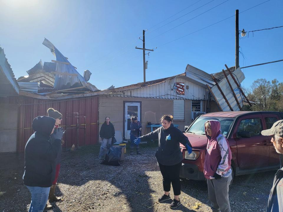 Chelsie Rodrigue and her mother Joan "Cookie" Burke speak with volunteers who are helping them clean up Cookie's Thrift Shop after it was hit by a tornado Jan. 8.