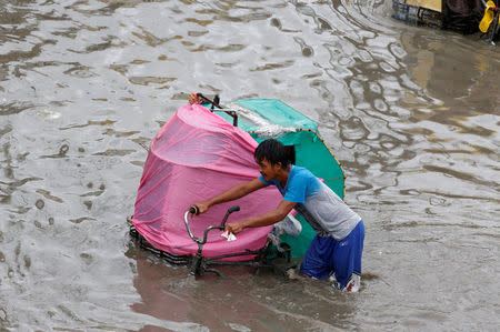 A man manoeuvres his pedicab in floodwaters in Las Pinas, Metro Manila as a storm sweeps across the main Luzon island, Philippines, September 12, 2017. REUTERS/Erik De Castro