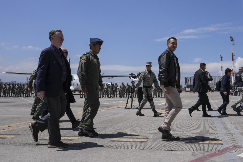 El presidente ecuatoriano, Daniel Noboa, al frente a la derecha, y el embajador de Estados Unidos en Ecuador, Michael J. Fitzpatrick, en el acto de entrega de un avión Hércules para misiones militares donado por el gobierno de Estados Unidos, en el aeropuerto de Cotopaxi en Latacunga, Ecuador, el lunes 25 de marzo de 2024. (AP Foto/Dolores Ochoa)