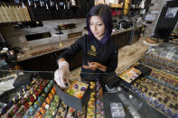 In this Monday, Sept. 16, 2019, photo Annie Rupani, owner of Cacao & Cardamom, fills a custom box with chocolates inside one her shops in Houston. She's seen the amount that people spend on each visit drop in the past year. Like many retailers, she's going to put more effort and investment into her online business. (AP Photo/David J. Phillip)