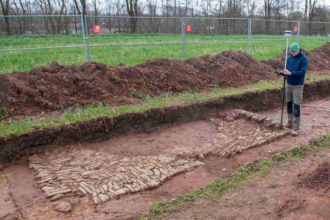 An archaeologist works near the bath house ruins.