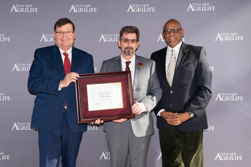 Mark Hussey, acting vice chancellor and dean of Agriculture and Life Sciences for Texas A&M, left, presents the 2021 Vice Chancellor’s Award in Excellence for Public Service in Forestry to Richard Gray, Texas A&M Forest Service chief regional fire coordinator, center, along with Al Davis, Texas A&M Forest Service interim director.