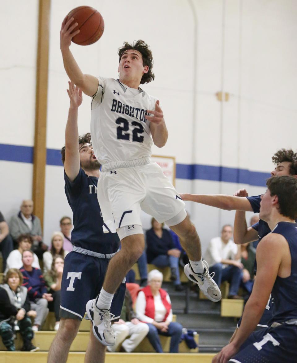 Brighton's Troy McPherson (22), center, drives to the basket over Thomas's Shawn Mason (13), left, during their Section V matchup Wednesday, Dec. 7, 2022 at Brighton High School.