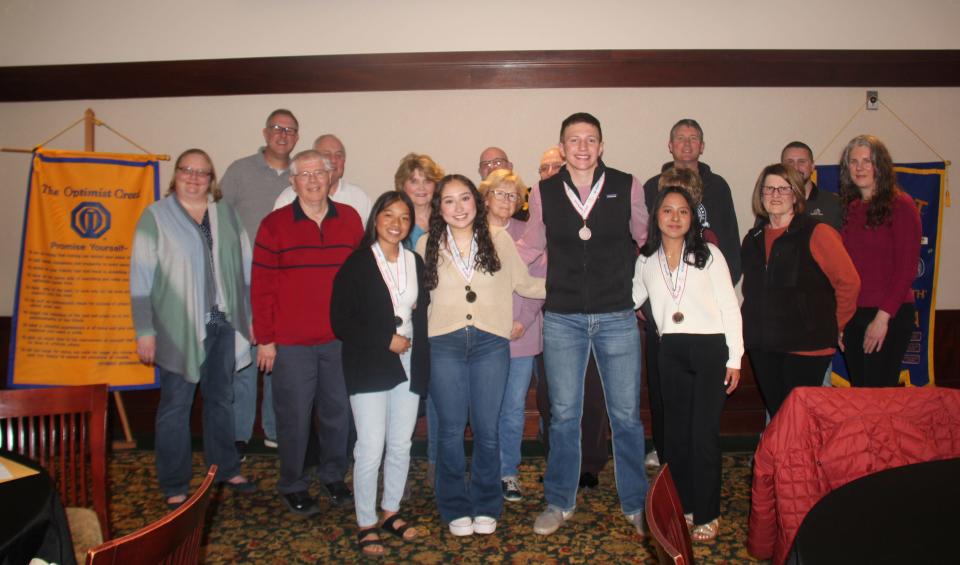 Perry Optimist Club members pose for a photo with the Perry High School and DMACC essay contest winners on Wednesday, April 3, 2024, at the Hotel Pattee.