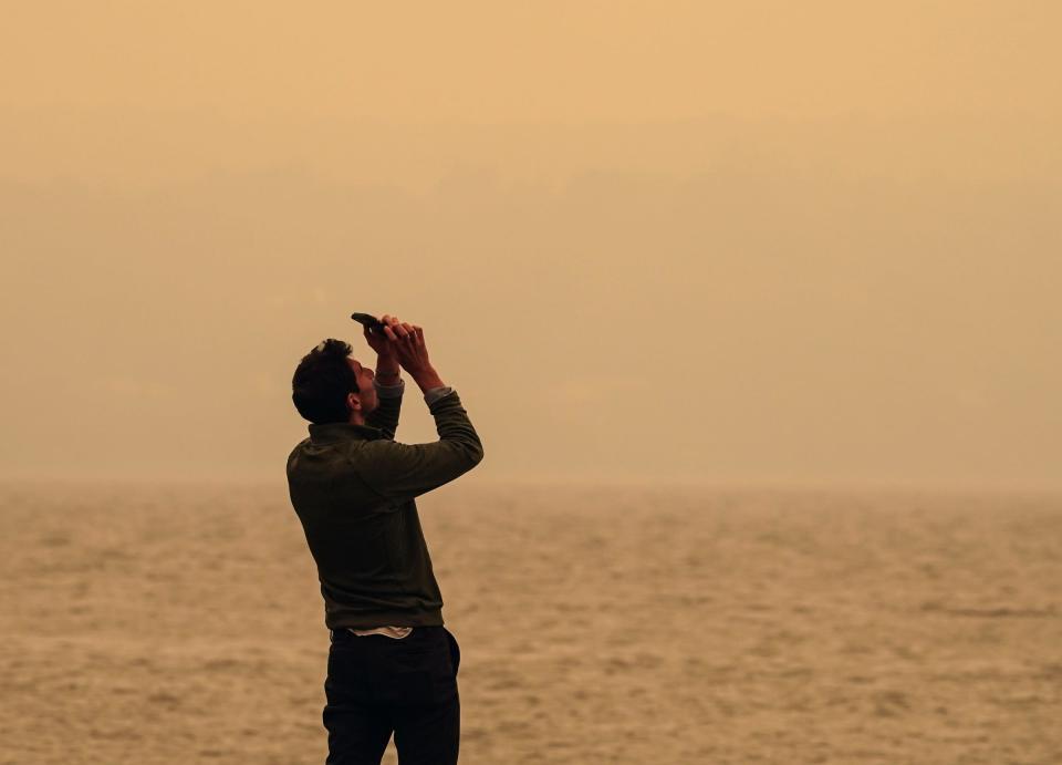 Andrew Elias of Montvale attempts to photograph the sun hidden by smoke from the Canadian wildfires on the Piermont Pier on Wednesday, June 7, 2023.