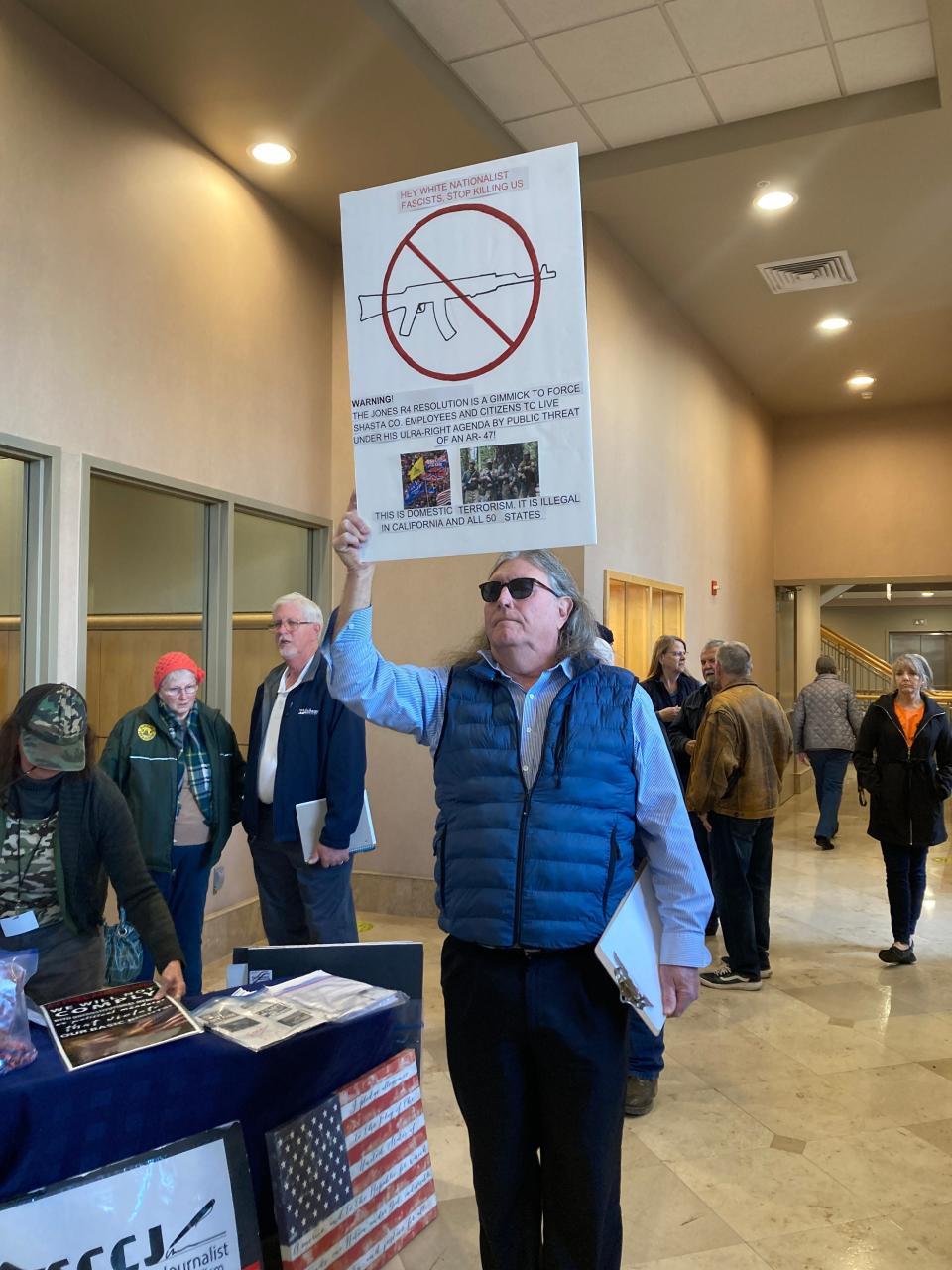 Christian Gardinier of Redding holds up a sign in the foyer of the Shasta County Supervisors chambers before the Tuesday, Feb. 21, 2023, meeting. Gardinier spoke out against the Second Amendment resolution during the meeting.