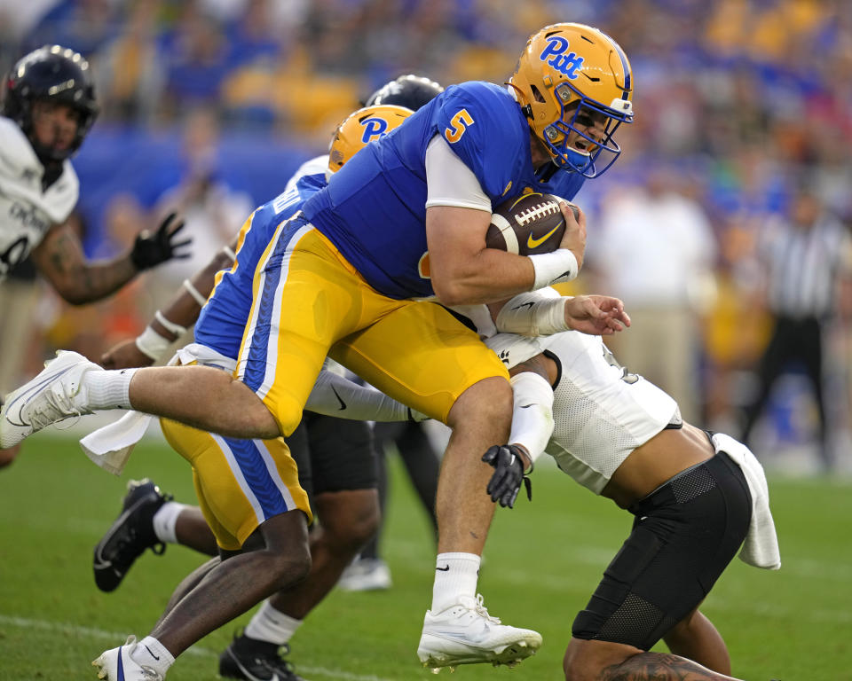 Pittsburgh quarterback Phil Jurkovec (5) is tackled by Cincinnati safety Deshawn Pace (3) after a 6-yard gain during the first half of an NCAA college football game in Pittsburgh on Saturday, Sept. 9, 2023. (AP Photo/Gene J. Puskar)