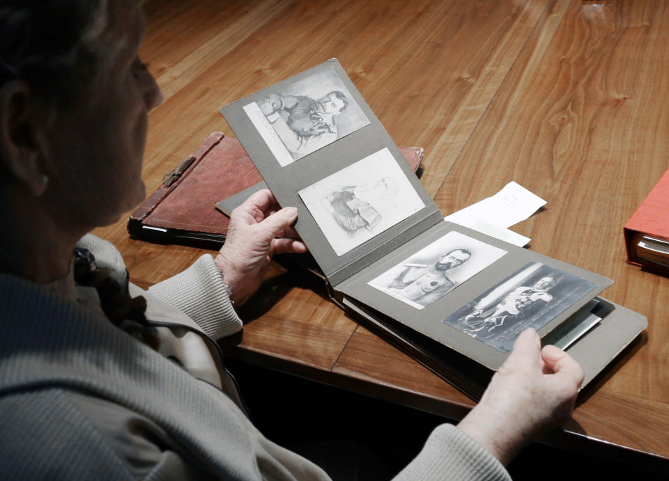 Dorothy McFerrin looks through an old family photo album from Russian Czar Nicholas II Friday, Feb. 1, 2013, in Houston. McFerrin and her husband, Artie, own one of the largest private collections of authentic Faberge, the czar's personal jeweler, items in the United States. Featuring more than 350 objects, the exhibit "Fabergé: A Brilliant Vision," runs through Dec. 31, 2013 at the Houston Museum of Natural Science. (AP Photo/Pat Sullivan)