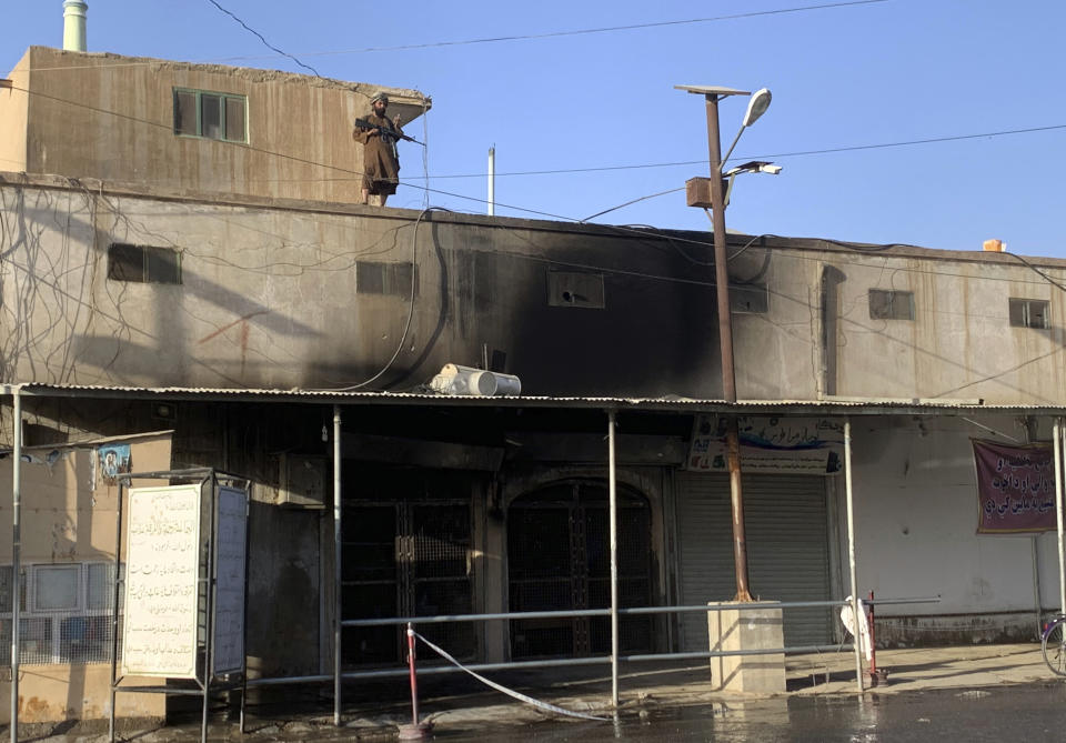 A Taliban fighter stands guard on the top of a mosque following a suicide bombers attack in the city of Kandahar, southwest Afghanistan, Friday, Oct. 15, 2021. Suicide bombers attacked a Shiite mosque in southern Afghanistan that was packed with worshippers attending Friday prayers, killing several people and wounding others, according to a hospital official and a witness. (AP Photo/Sidiqullah Khan)