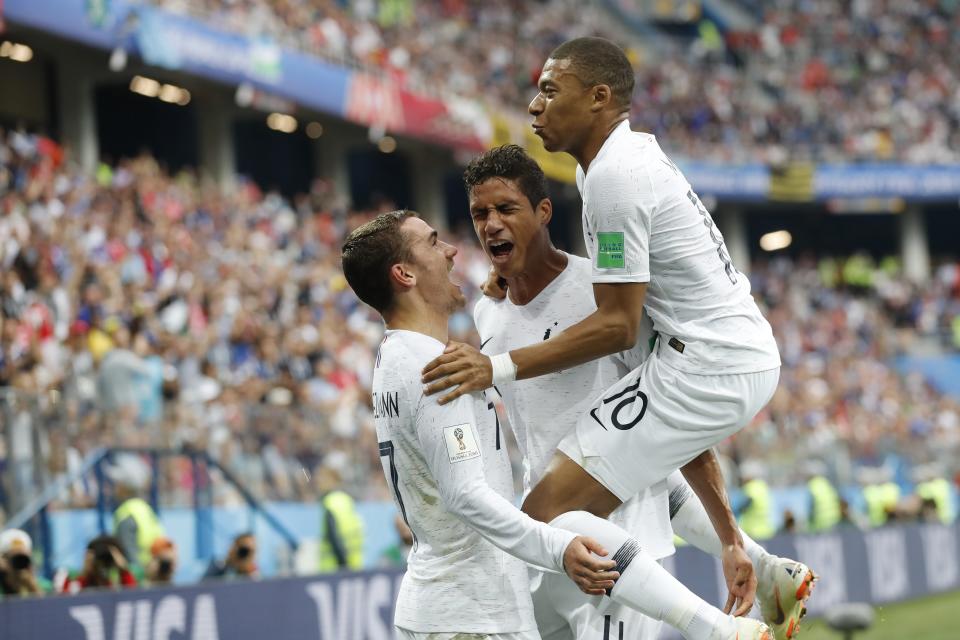 Kylian Mbappe, Antoine Griezmann and Raphael Varane celebrate one of their two goals in France’s World Cup quarterfinal victory over Uruguay. (AP)