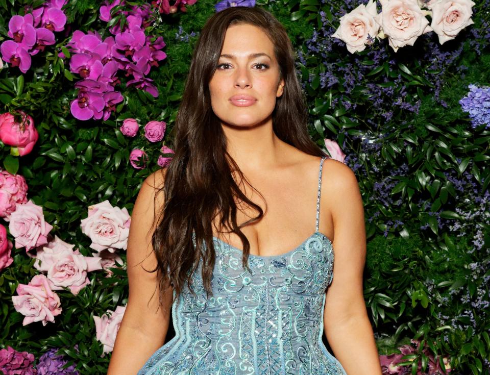 A close-up of Ashley with a floral backdrop