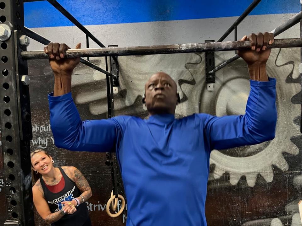 Marine Corps veteran Felix Harris warms up for the Murph workout set on Memorial Day, May 29, 2023, in Ocala as Zone Heath & Fitness coach Nikki Bruno looks on.