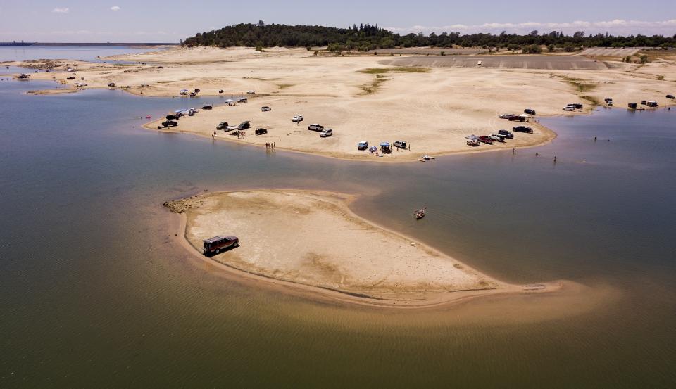 FILE - A vehicle is parked on a newly revealed piece of land due to receding waters at the drought-stricken Folsom Lake in Granite Bay, Calif., on Saturday, May 22, 2021. Months of winter storms have replenished California's key reservoirs after three years of punishing drought. (AP Photo/Josh Edelson, File)