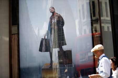 FILE PHOTO: An advertisement containing a jacket with Burberry logo pattern is pictured at a window of a Burberry store in central London