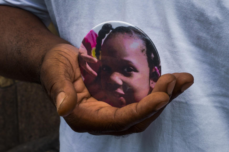 Nathan Wallace stands outside of his home holding a button showing his daughter, Natalia Wallace, on Monday, Aug. 3, 2020, in Chicago. Natalia, 7, was killed on the west side of Chicago on July 4, 2020. (AP Photo/Matt Marton)