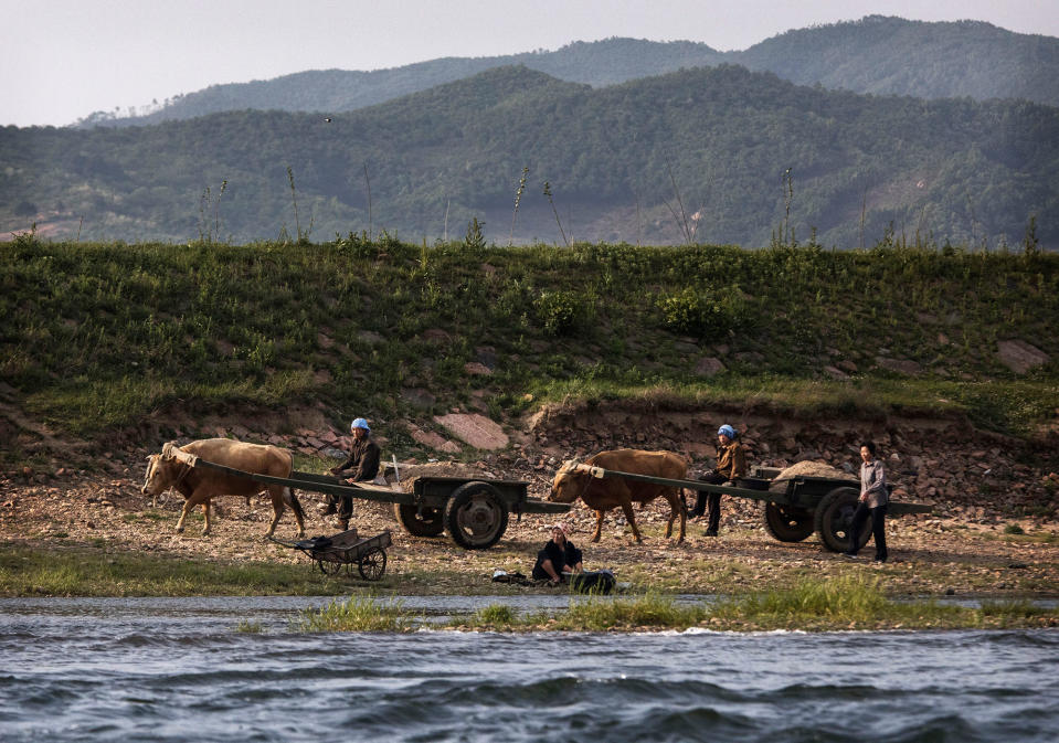 North Korean farmers work along the river