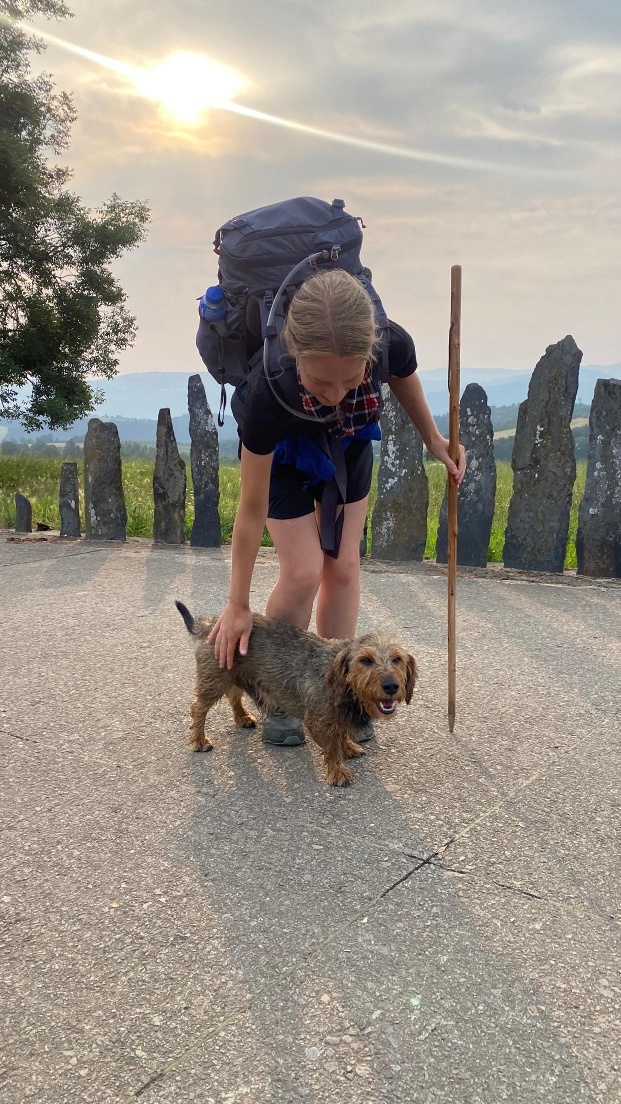 Megan Thorson petting a dog while hiking the Camino de Santiago