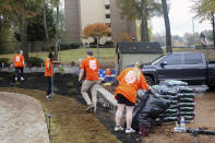 In this photo provided by Gabriella Rico, volunteers from Home Depot work to build a garden and water feature on the campus of the Veterans Empowerment Organization in Atlanta, Nov. 10, 2023. Company employees have volunteered more than 1.5 million hours in service to veterans, including building or repairing 60,000 houses and facilities for former service members. (Gabriella Rico via AP)