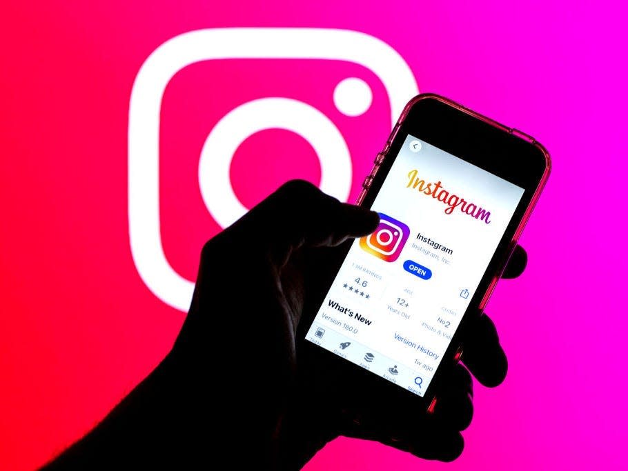 the Instagram app in App Store seen displayed on a smartphone screen and a Instagram logo in the background.