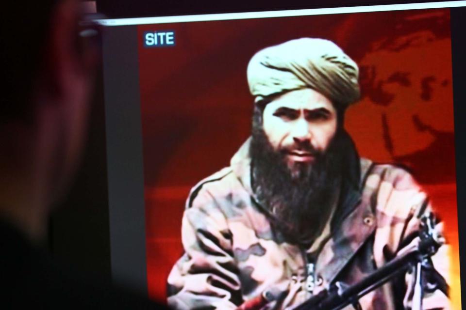 A man looks at a picture of Abdelmalek Droukdel in 2010 (AFP via Getty Images)