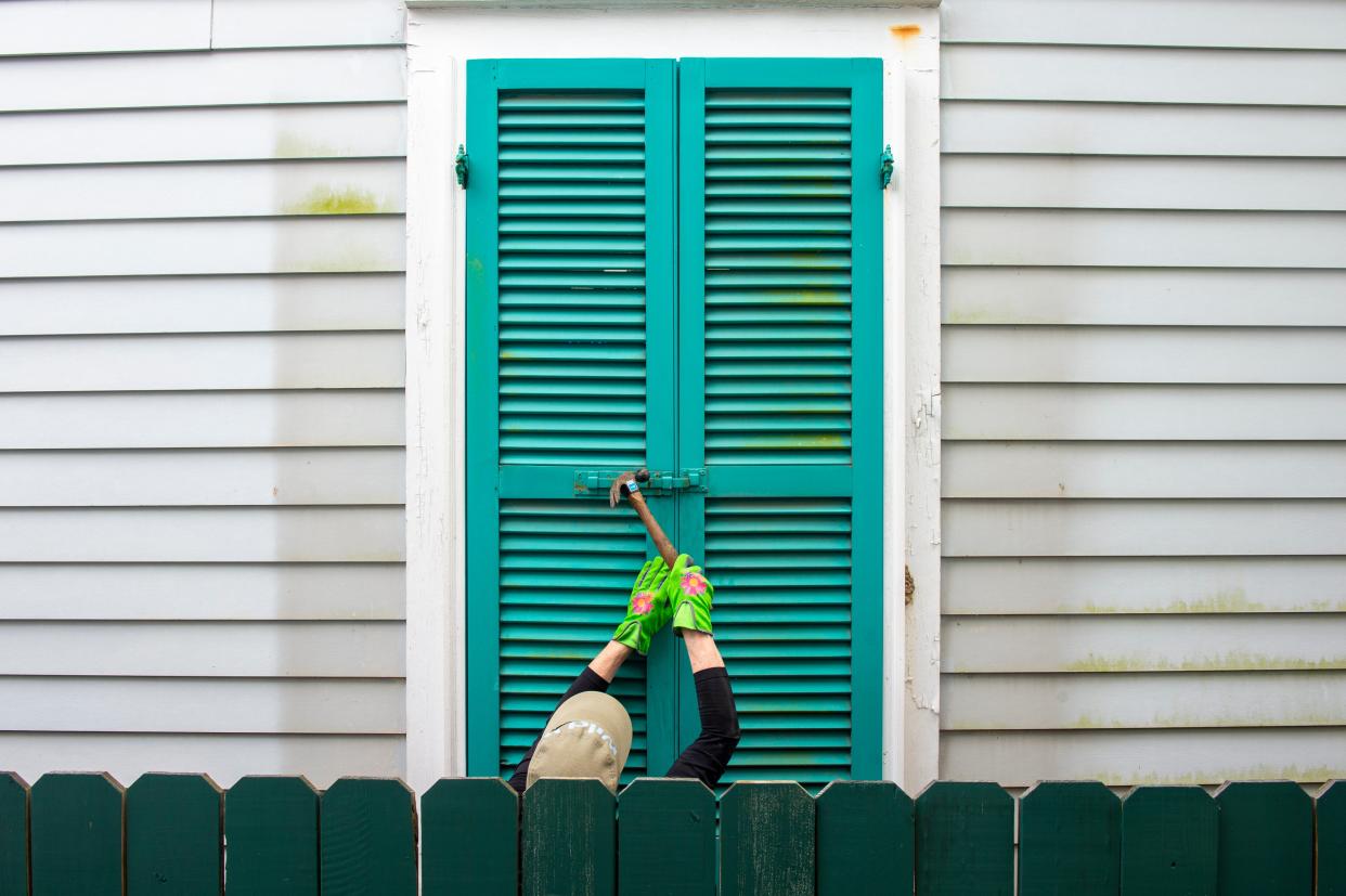 Storm shutters are hammered closed on a 100-year-old house, Friday, August 27, 2021, in New Orleans, as residents prepare for Hurricane Ida on.  (AP)