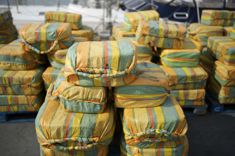 Bales of cocaine weighting some 5,2 tons and a seized yacht are displayed for the media at a Portuguese Navy base in Almada, south of Lisbon, Monday, Oct. 18, 2021. Portuguese police said Monday the seizure was the largest in Europe in recent years and the biggest in Portugal for 15 years. Police localized and intercepted the 24-meter (79-foot) yacht at sea. The operation involved police from Portugal, Spain, the Drug Enforcement Agency in the United States and the United Kingdom's National Crime Agency. (AP Photo/Armando Franca)