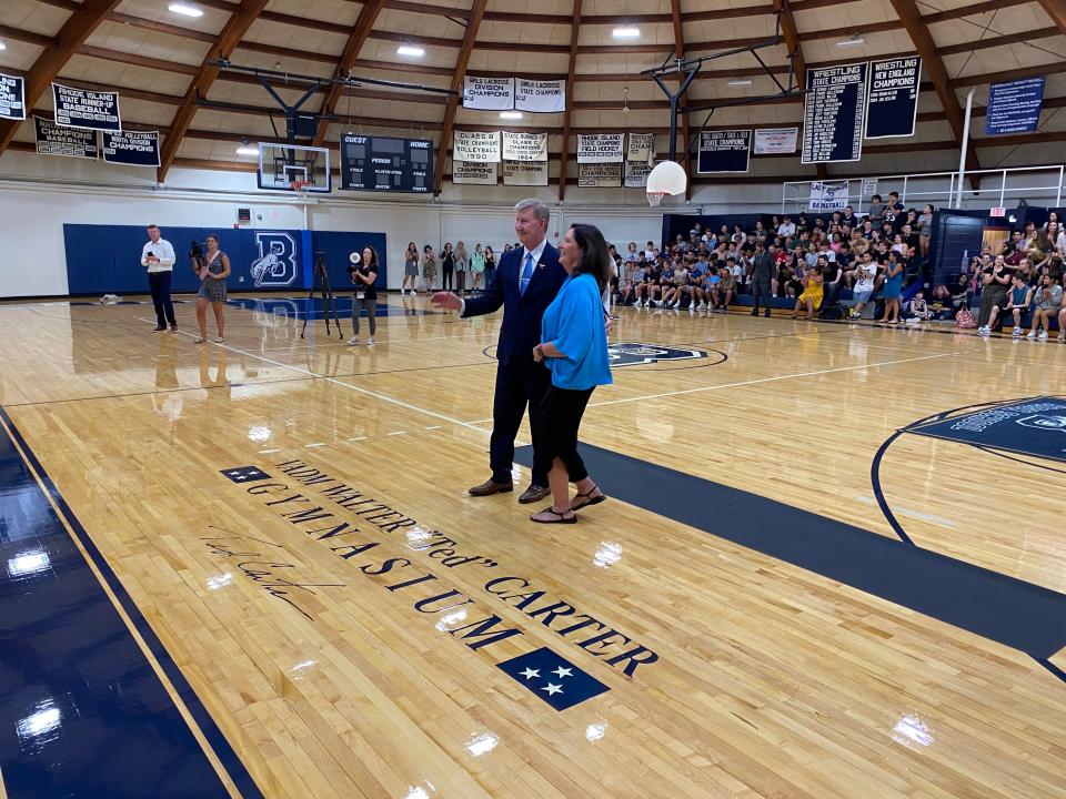 Retired Vice Admiral Ted Carter and his wife, Lynda, stand on the floor of the Burrillville High School gym after it was renamed in his honor on Friday.