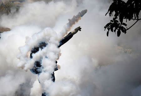 Un manifestante arroja una granada de gas lacrimógeno hacia la policía antidisturbios durante la llamada "madre de todas las marchas" contra el presidente de Venezuela, Nicolás Maduro, en Caracas. 19 de abril 2017.Por segundo día consecutivo, miles de partidarios de la oposición salieron el jueves a las calles de Venezuela para protestar en contra del presidente Nicolás Maduro, a quien acusan de la grave crisis económica y de haber desvirtuado su Gobierno al convertirlo en una dictadura.REUTERS/Carlos Garcia Rawlins