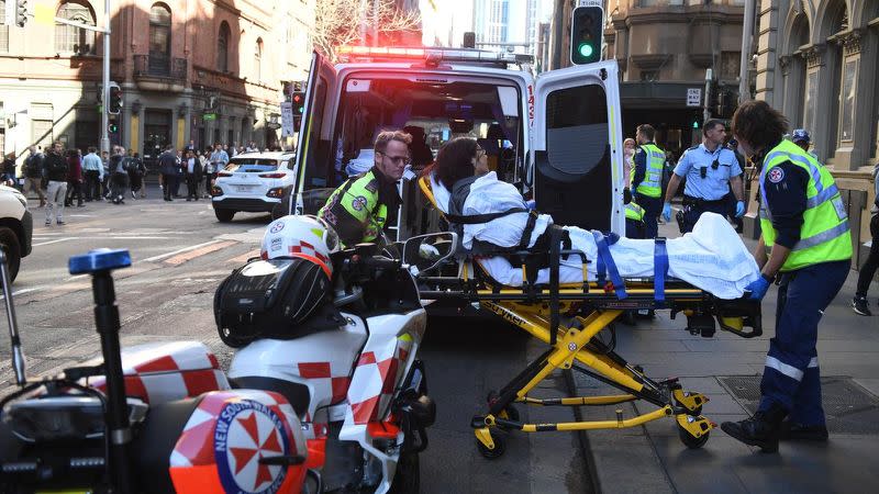 A women on a stretcher is taken by ambulance from Hotel CBD at the corner of King and York Street in Sydney.