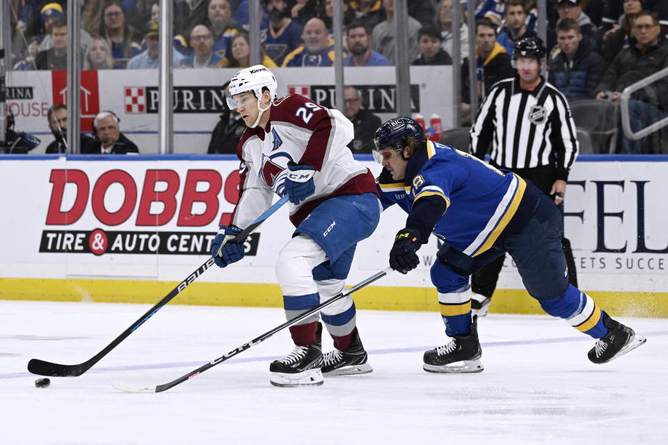 Colorado Avalanche's Nathan MacKinnon (29) works the puck against St. Louis Blues' Mackenzie MacEachern (28) during the first period of an NHL hockey game Friday, Dec. 29, 2023, in St. Louis. (AP Photo/Michael Thomas)