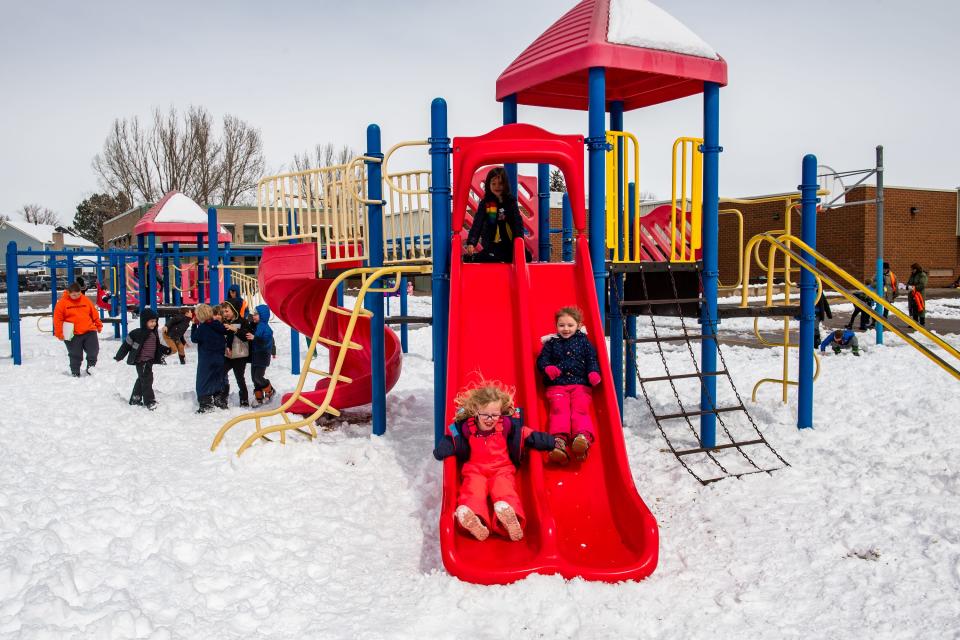 First-graders Eleanor Brune, bottom left, and Skylar Keesler go down a slide during recess at Shepardson Elementary School on Monday, March 27, 2023, in Fort Collins.