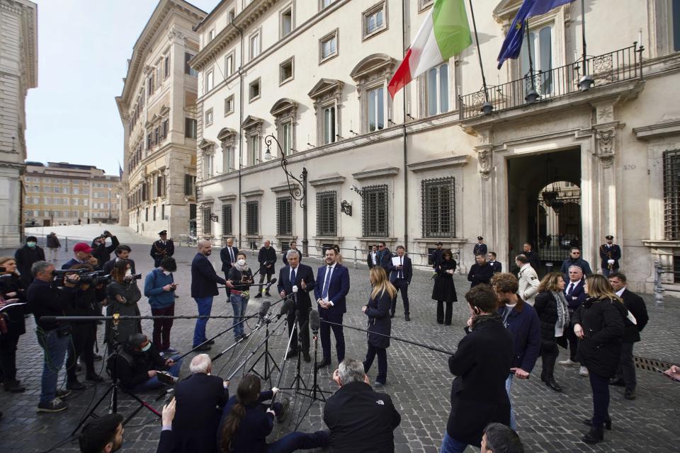 Journalists keep their distance as the League leader Matteo Salvini, center, is flanked by Brothers of Italy Giorgia Meloni, right, and former European Parliament President Antonio Tajani give a statement to journalists after meeting with Italian Premier Giuseppe Conte, outside Chigi palace in Rome, Tuesday, March 10, 2020. Italy entered its first day under a nationwide lockdown after a government decree extended restrictions on movement from the hard-hit north to the rest of the country to prevent the spreading of coronavirus.  (AP Photo/Andrew Medichini)