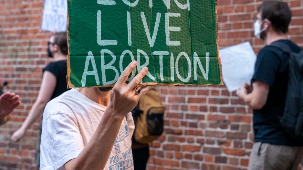 protester holding a sign that reads long live abortion