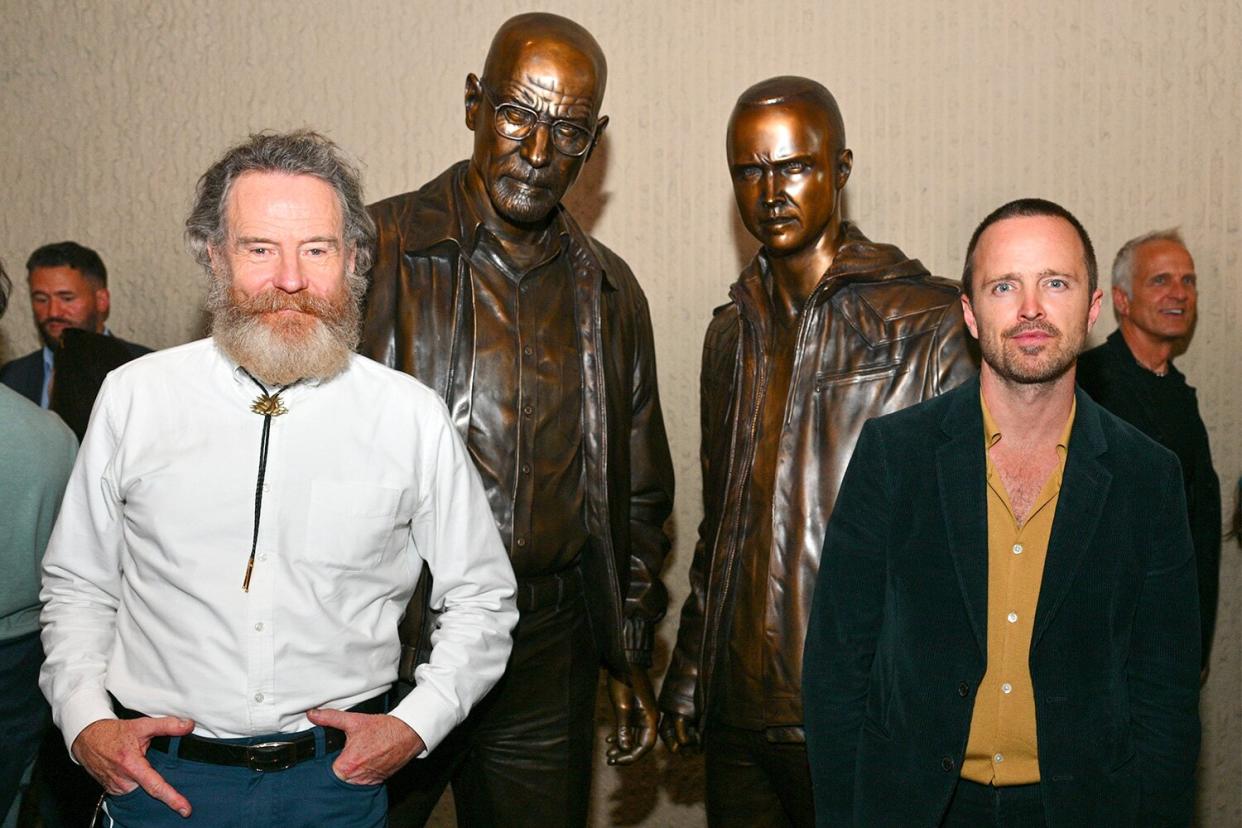 Bryan Cranston (L) and actor Aaron Paul pose with bronze statues depicting television characters Walter White, played by Cranston, and Jesse Pinkman, played by Paul, from the series "Breaking Bad" at the Albuquerque Convention Center on July 29, 2022 in Albuquerque, New Mexico.