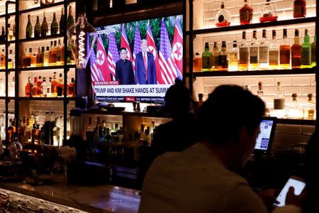 A television screen at the Baro bar broadcasts the Singapore summit meeting between U.S. President Donald Trump and North Korean leader Kim Jong Un, as customers sit at the bar in the Korea Town section of Manhattan, New York, U.S., June 11, 2018. REUTERS/Andrew Kelly/Files