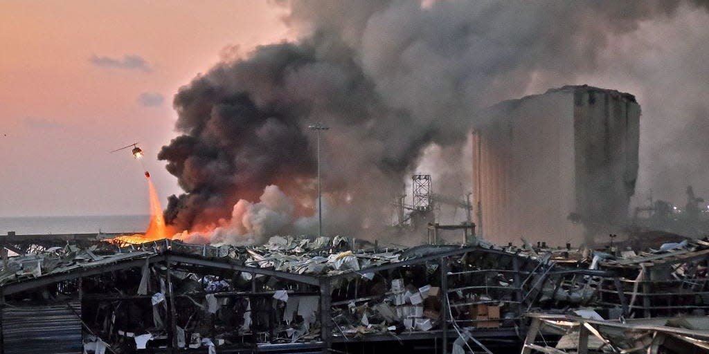 A helicopter puts out a fire at the scene of an explosion at the port of Lebanon's capital Beirut on August 4, 2020.