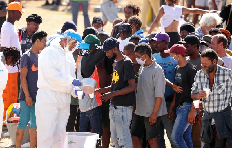 Homeless people queue for food at a camp set up by disaster management authorities during the 21-day nationwide lockdown aimed at limiting the spread of coronavirus disease (COVID-19) in Cape Town