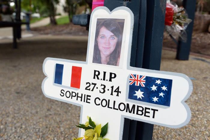 A cross bearing the name and photo of murdered French student Sophie Collombet at the scene of the crime in Brisbane in 2014. Image: AAP