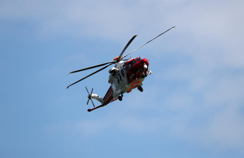 A rescue helicopter of the Coast Guard is seen near the scene of a derailed passenger train, in Carmont, Stonehaven, Scotland, Britain, August 12, 2020. REUTERS/Russell Cheyne