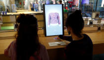 Staff members proceed with the measuring process on a computer to order a knitting pattern at the Adidas Knit for You store in Berlin, Germany March 7, 2017. Picture taken March 7, 2017. REUTERS/Fabrizio Bensch